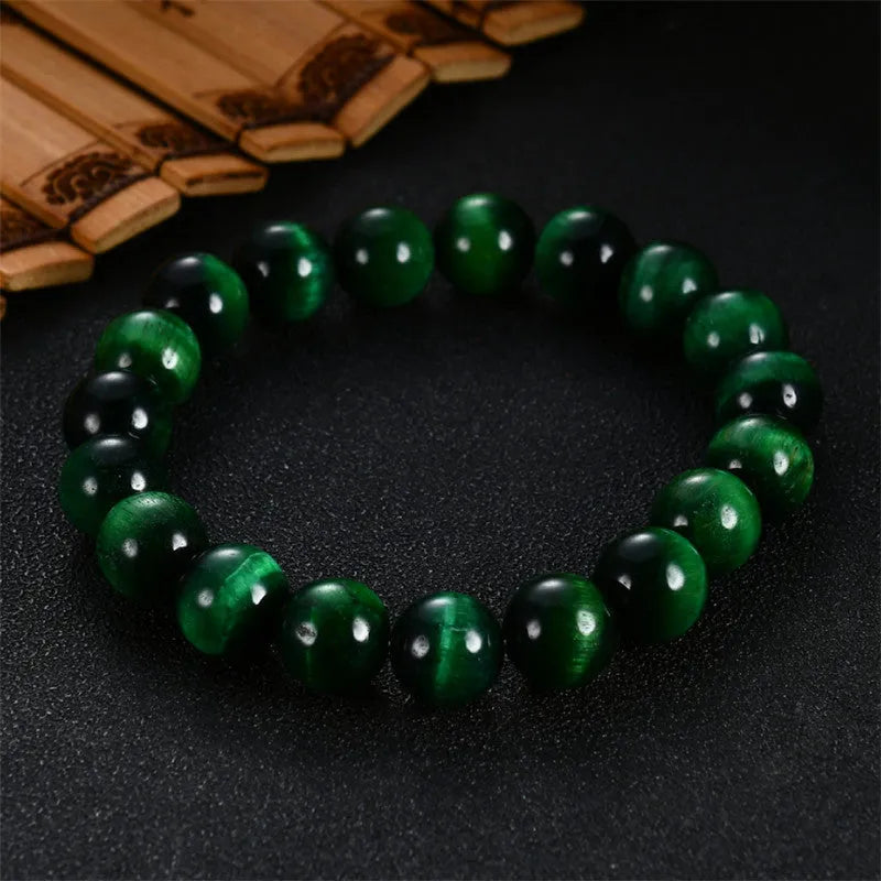 Green polished Tiger Eye stone bracelet with geometry beads, shown on a wrist.