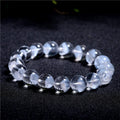 Women's natural white ghost pyramid crystal bracelet showing textured surfaces and ruyi charm detail