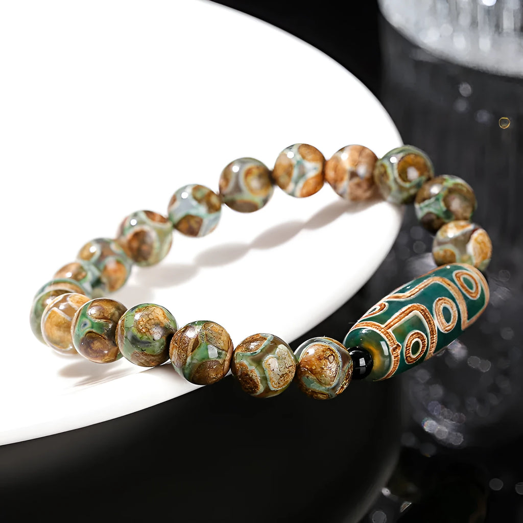 Handmade green dzi bead barrel shaped bracelet with 8mm natural agate beads on white background