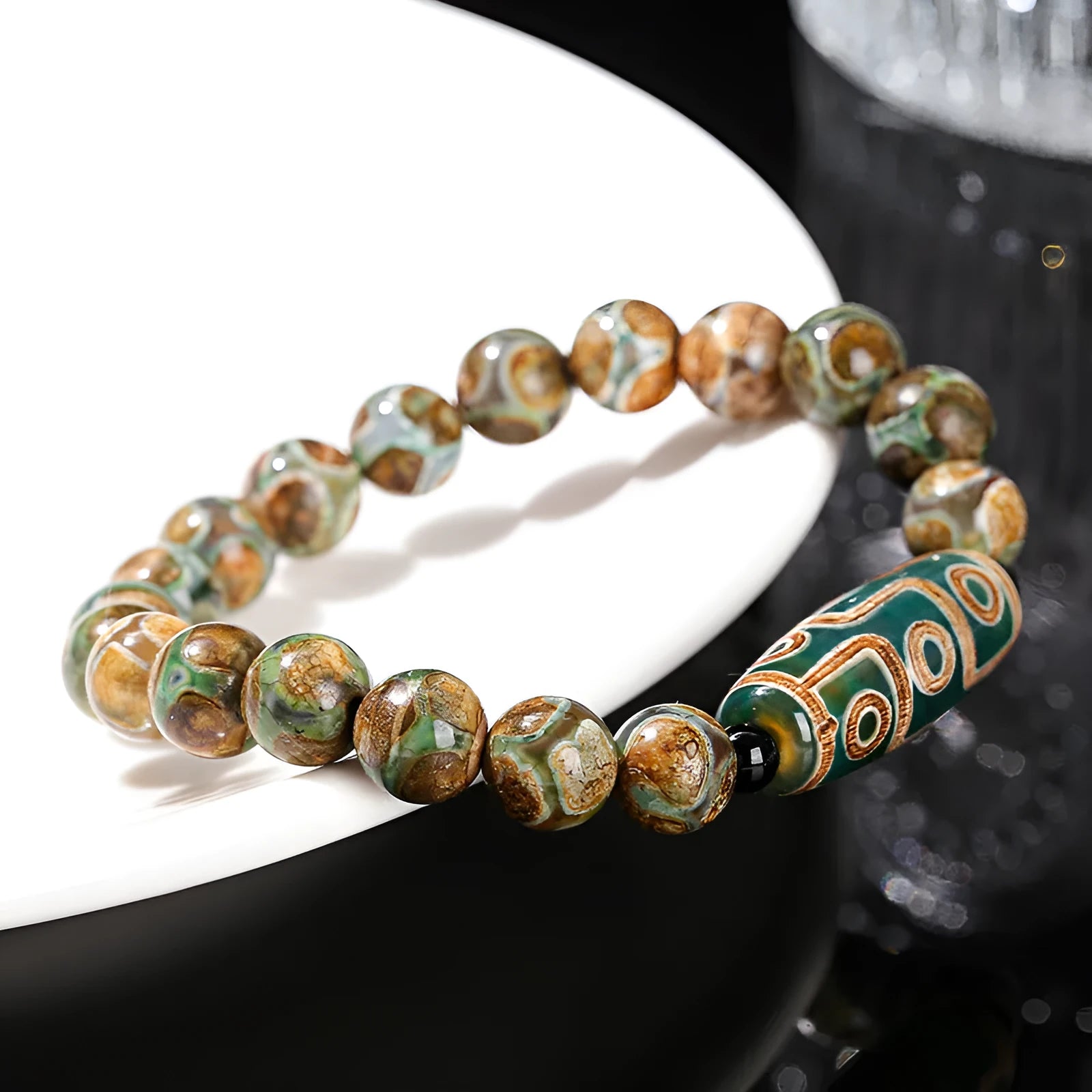 Handmade green dzi bead barrel shaped bracelet with 8mm natural agate beads on white background