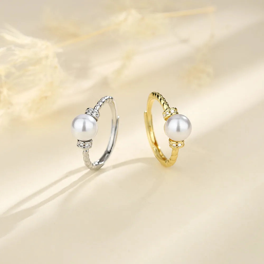 Adjustable antique-style copper ring with a geometric shape and an inlaid pearl, shown in gold and silver colour options.