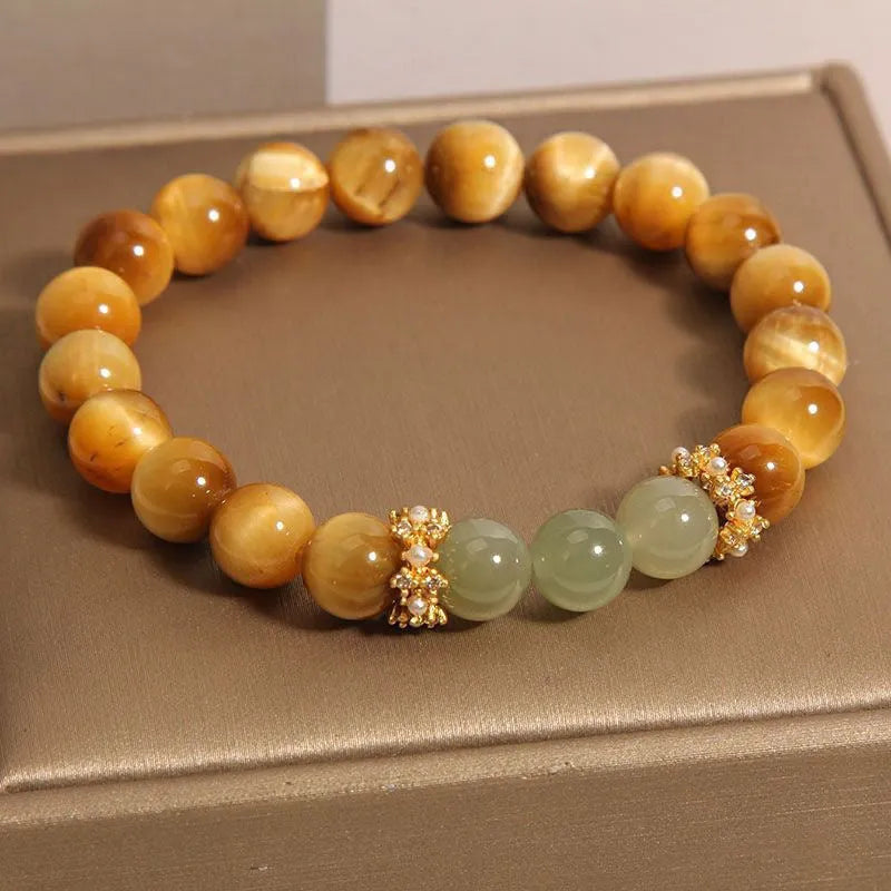 Natural yellow tiger's eye bracelet with U-shaped design showing auspicious patterns and traditional symbolic charms