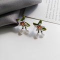 Silver colour needle camellia flower earrings showing stud and clip-on styles.