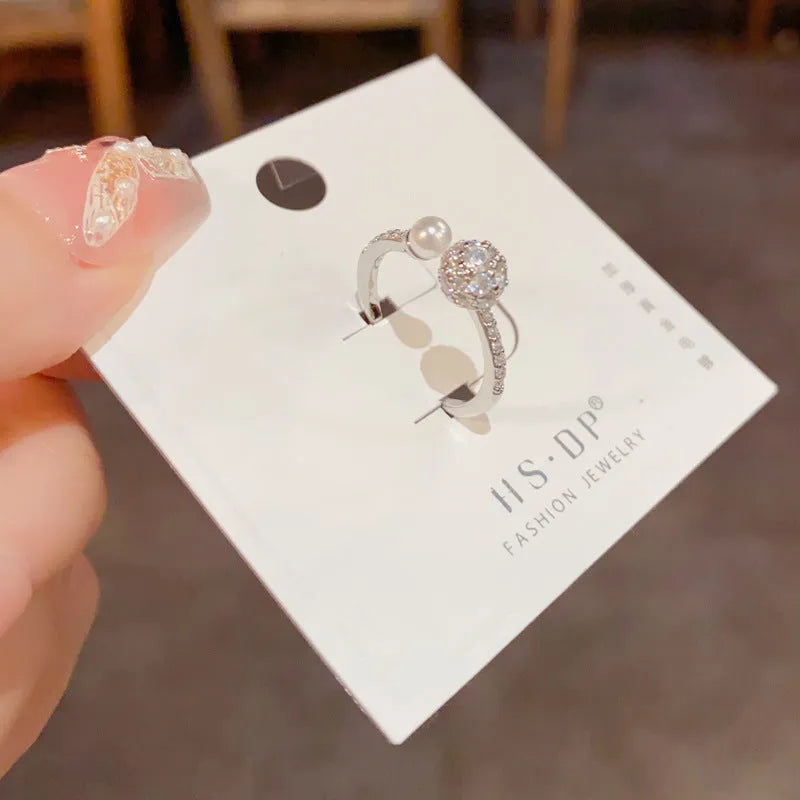 Women's open-end pearl ring with round zircon on geometric copper design in gold plating