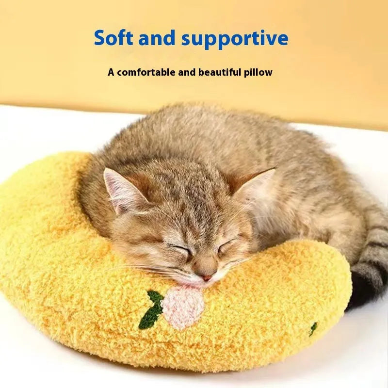 Blue and yellow question mark shaped cat pillow mat next to a moon shaped pet bed.