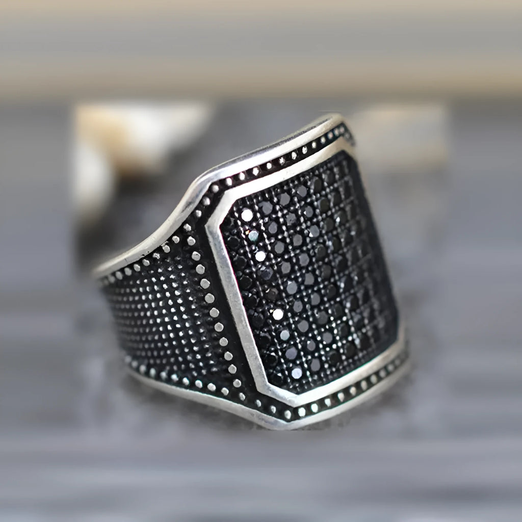 Black alloy ring with copper inlay and zircon detailing shown in unisex design