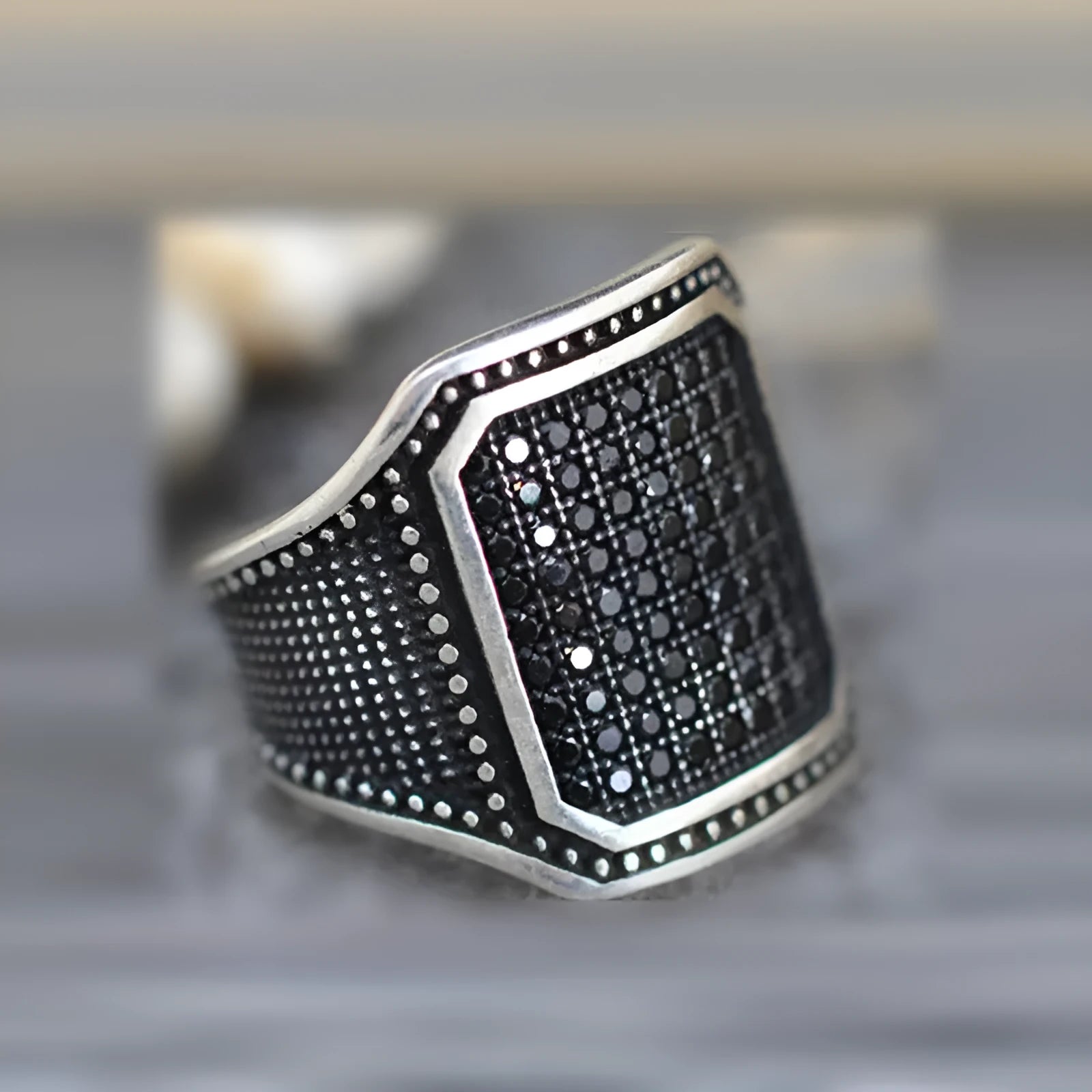 Black alloy ring with copper inlay and zircon detailing shown in unisex design