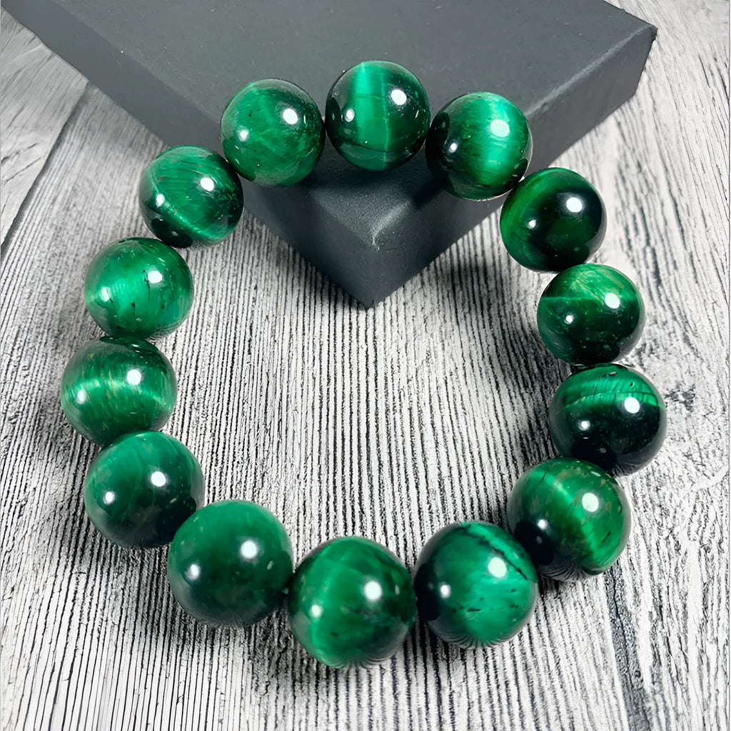 Green polished Tiger Eye stone bracelet with geometry beads, shown on a wrist.