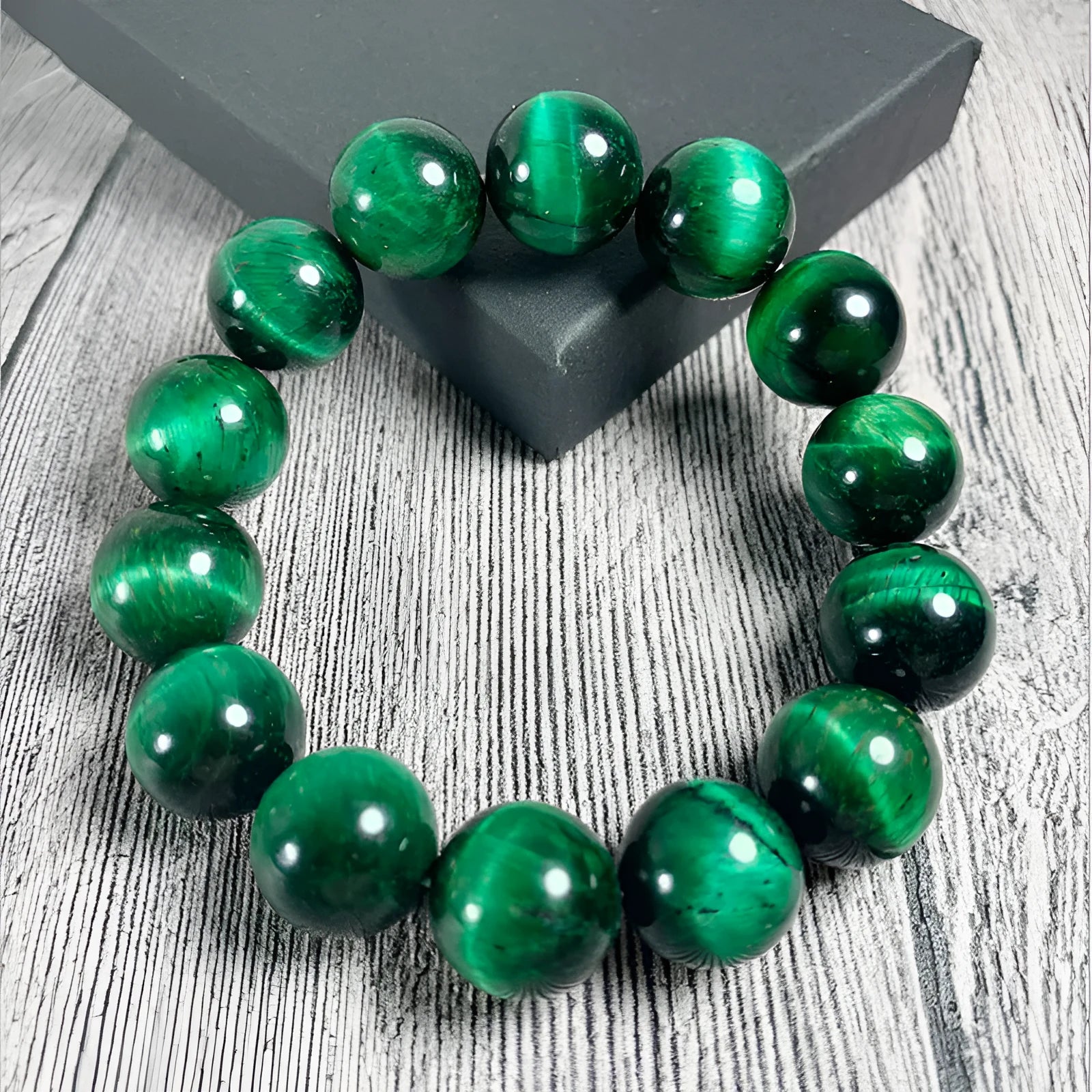 Green polished Tiger Eye stone bracelet with geometry beads, shown on a wrist.