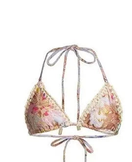 Creamy-white floral print women's three-piece bikini set with top, briefs, and skirt on a beach background.