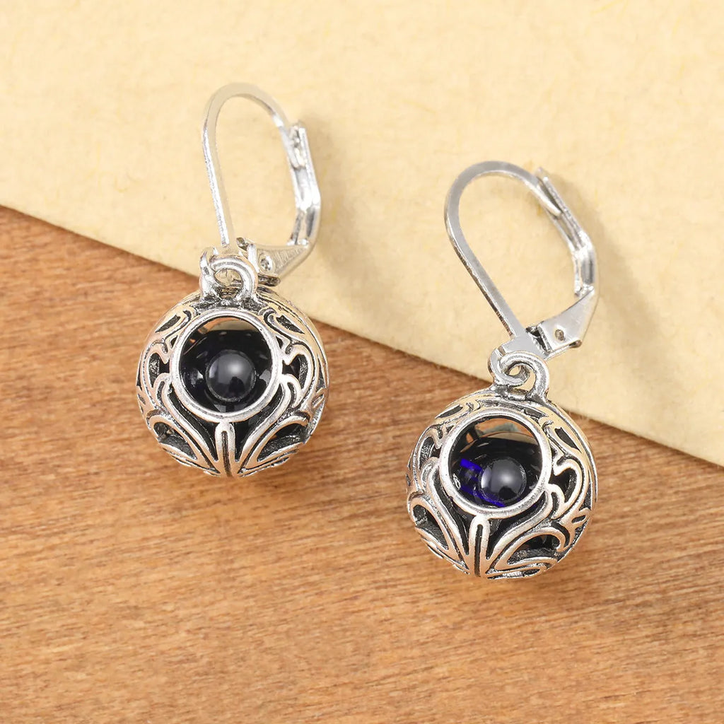 Vintage silver hollow pendant earrings with blue gemstone accent on geometric drop shape