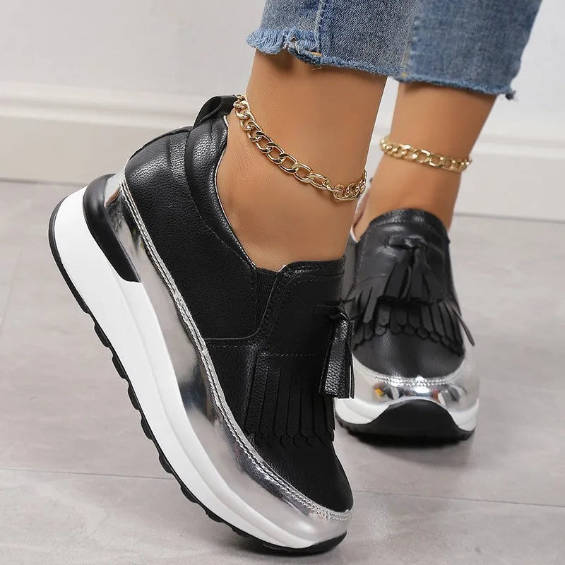 Women's black tassel platform casual shoe with wedge heel, low top, and round toe on a white background