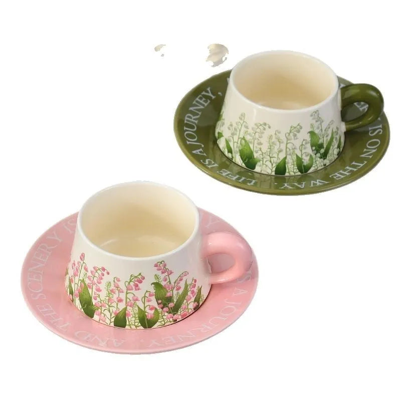 Ceramic coffee cup saucer set with two cups, two plates, and two spoons in matching design