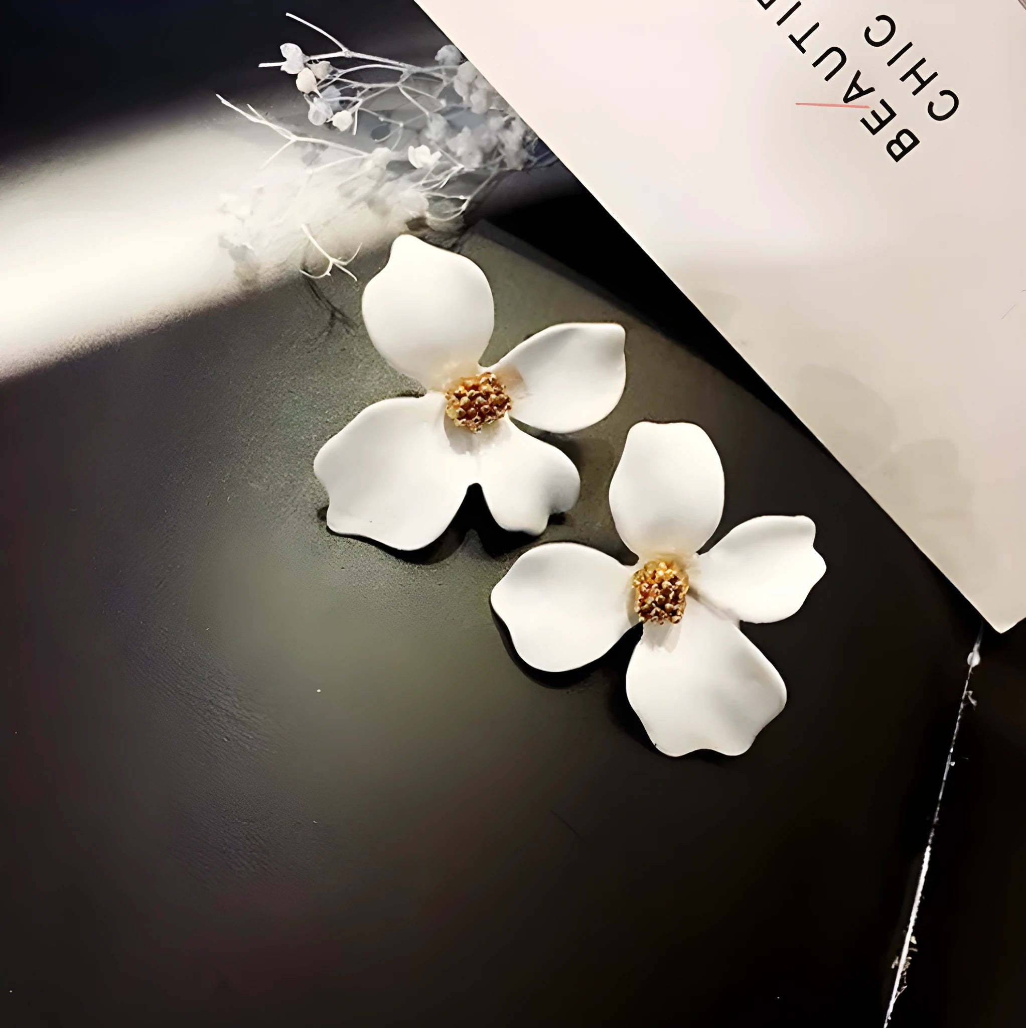 A pair of flower-shaped stud earrings for women in either pink or white alloy with an electroplated finish.