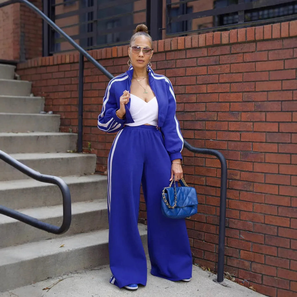 A grey striped polyester sweater with a zipper, paired with matching trousers, laid flat.