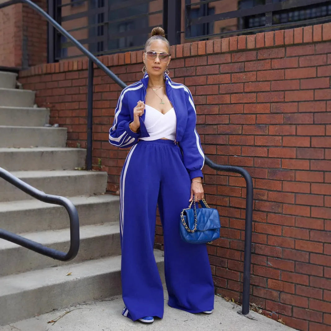 A grey striped polyester sweater with a zipper, paired with matching trousers, laid flat.