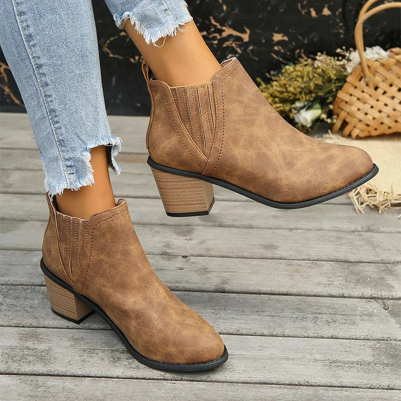 Black women's pointed toe ankle boots with a thick square low heel and slip-on design.