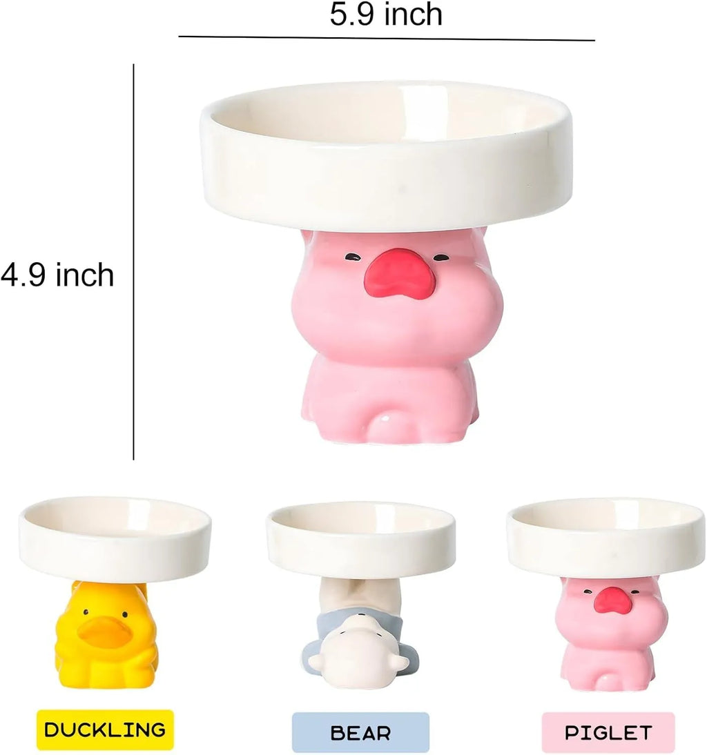 A raised ceramic cat bowl in an animal design, showing its height and wide opening for whisker-friendly feeding.