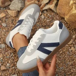 Women's blue flat German training shoes with artificial PU upper and rubber sole, low-top profile, side view