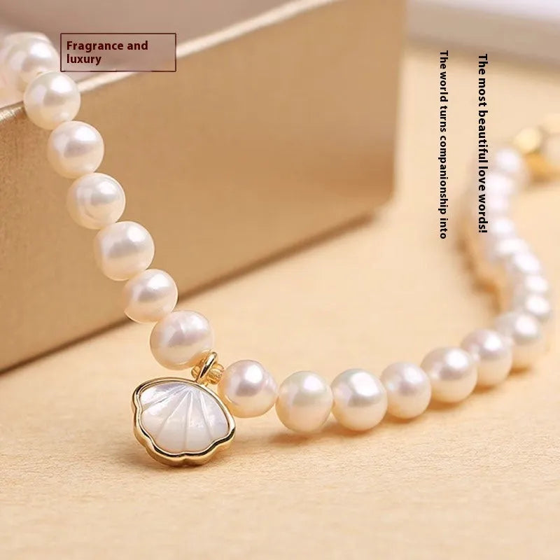 Women's freshwater pearl bracelet with fan-shaped design and alloy shell clasp, showing elastic string and extension chain options.