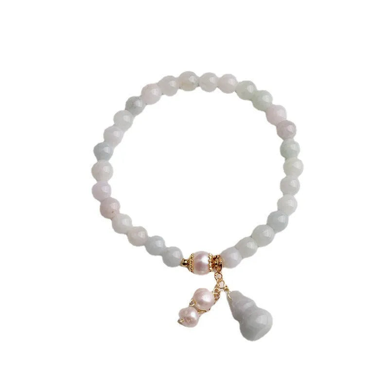 Close-up of a Chinese style jade bracelet for women featuring a natural emerald jade gourd charm on a band.