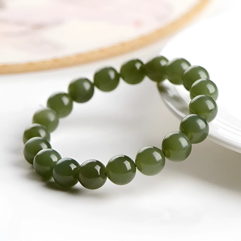 Polished Hetian jade ball bracelet in ice-like clear water colour on a wrist, showing bead detail.