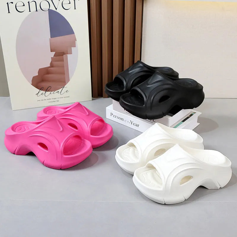 Women's thick-soled EVA slippers in rose red, white and black colours on a beach background.