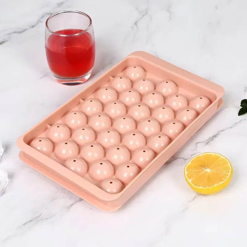Blue silicone ice cube tray with lid showing 33 round moulds for large ice