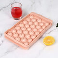 Blue silicone ice cube tray with lid showing 33 round moulds for large ice