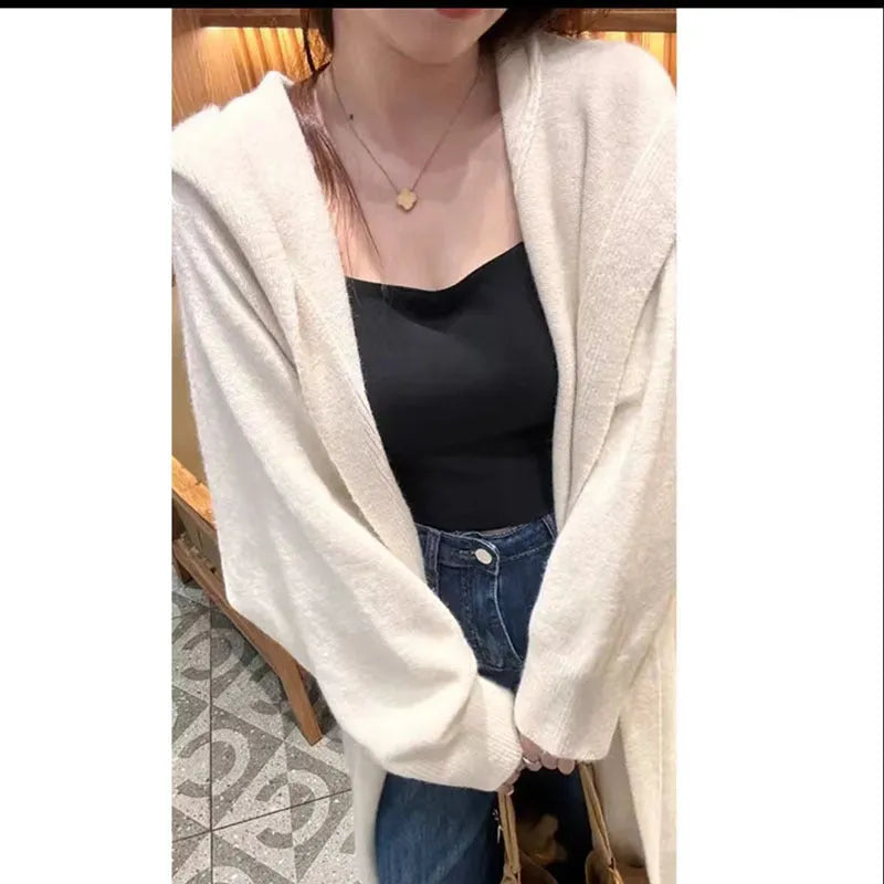 Woman wearing a long, loose, hooded knitted cardigan in a neutral colour, Korean casual style.