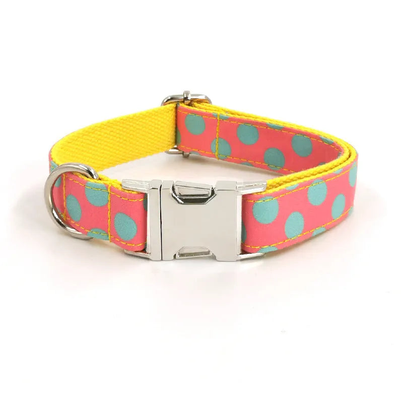 Yellow polka dot dog collar with bow and matching hand-held traction rope on white background