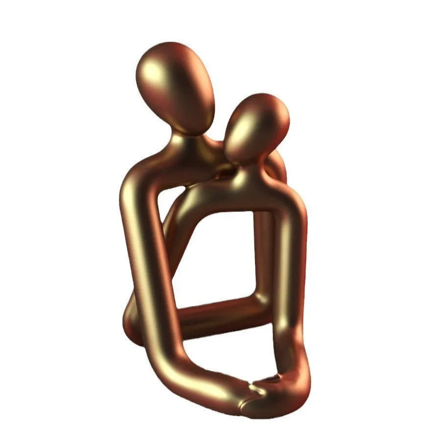 Modern couple resin statue in gold colour placed on a white bookshelf as home decor accent