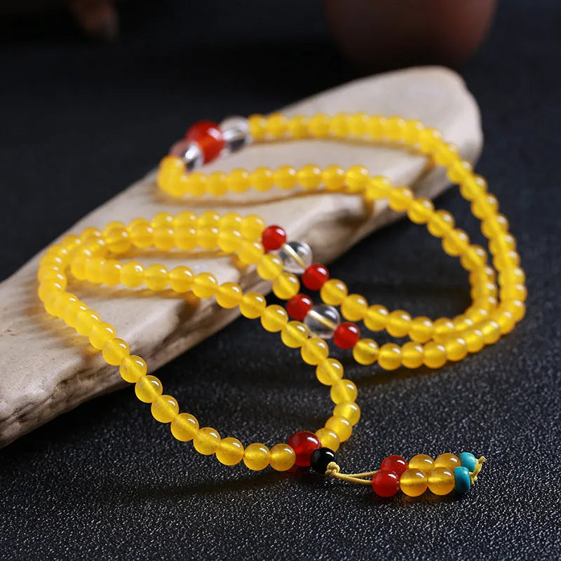 Polished crystal canary stone 108-bead geometric necklace with Lucky Cat detail on white background