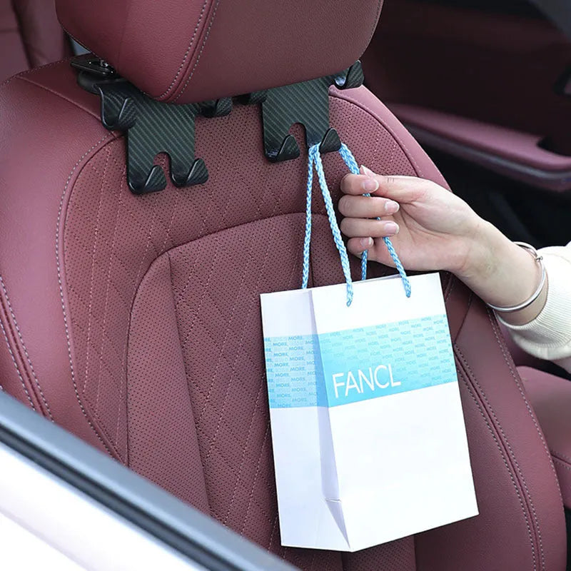 Black ABS plastic car seat back hook with integrated mobile phone holder bracket.