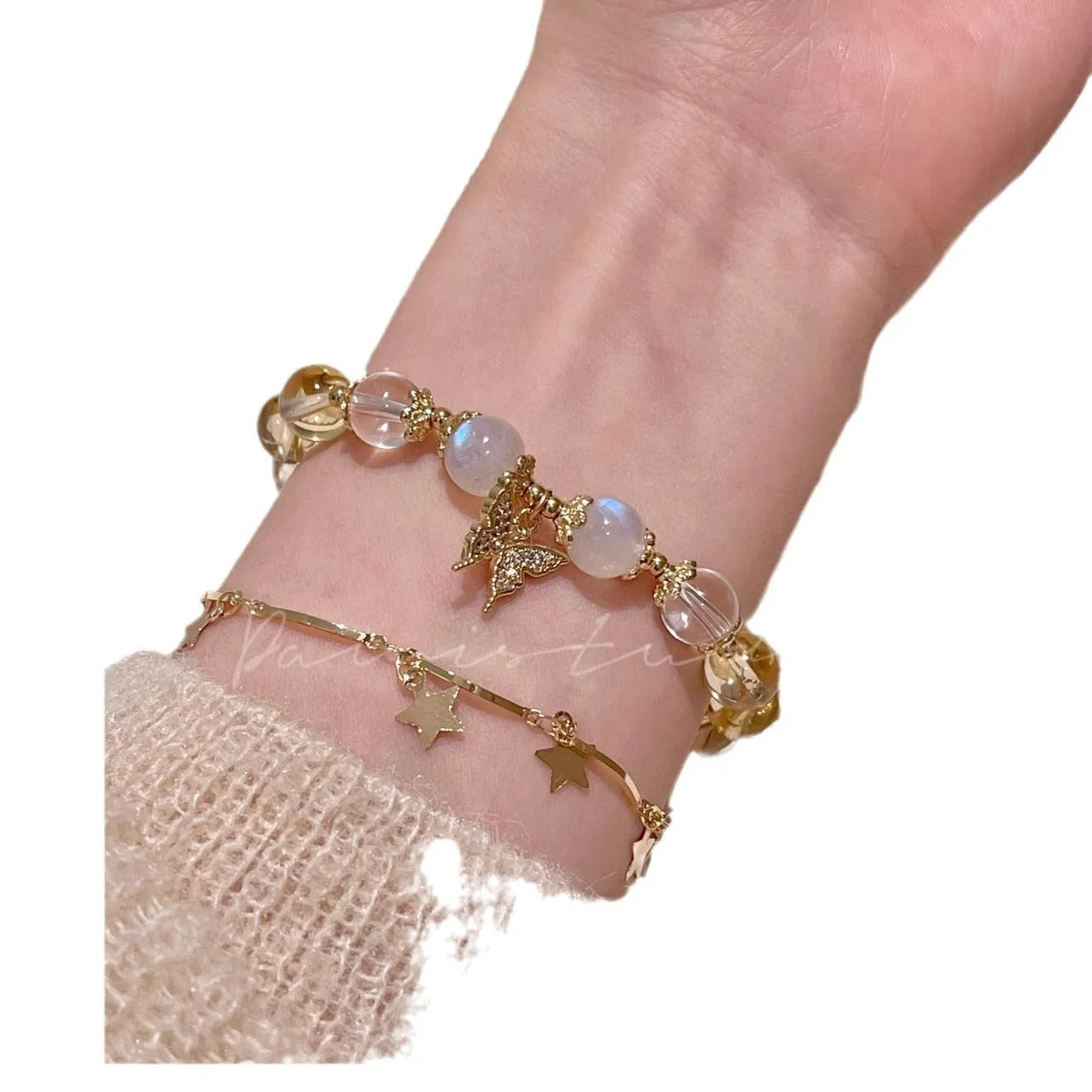 Moonstone white crystal beaded bracelet with citrine butterfly pendant on a white background