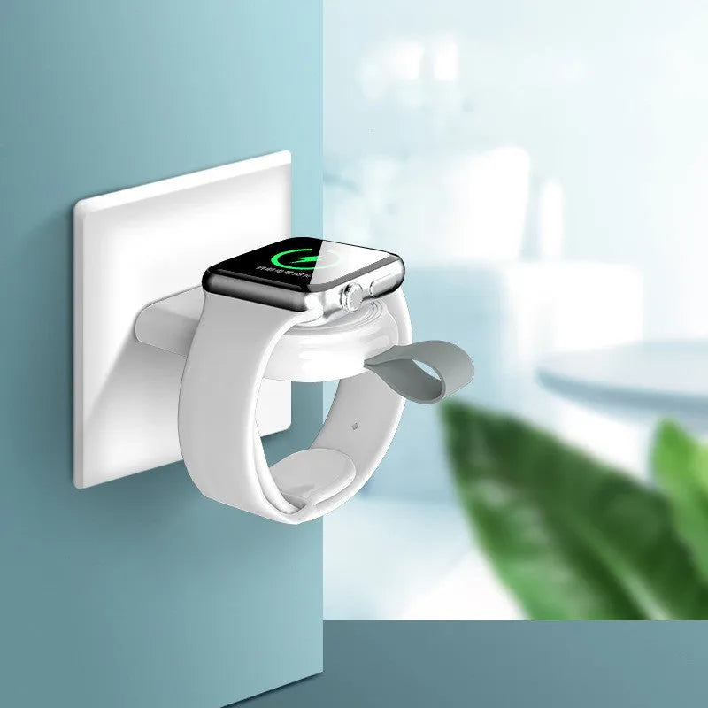 Portable wireless Apple Watch charging dock in white on a desk, with USB cable attached
