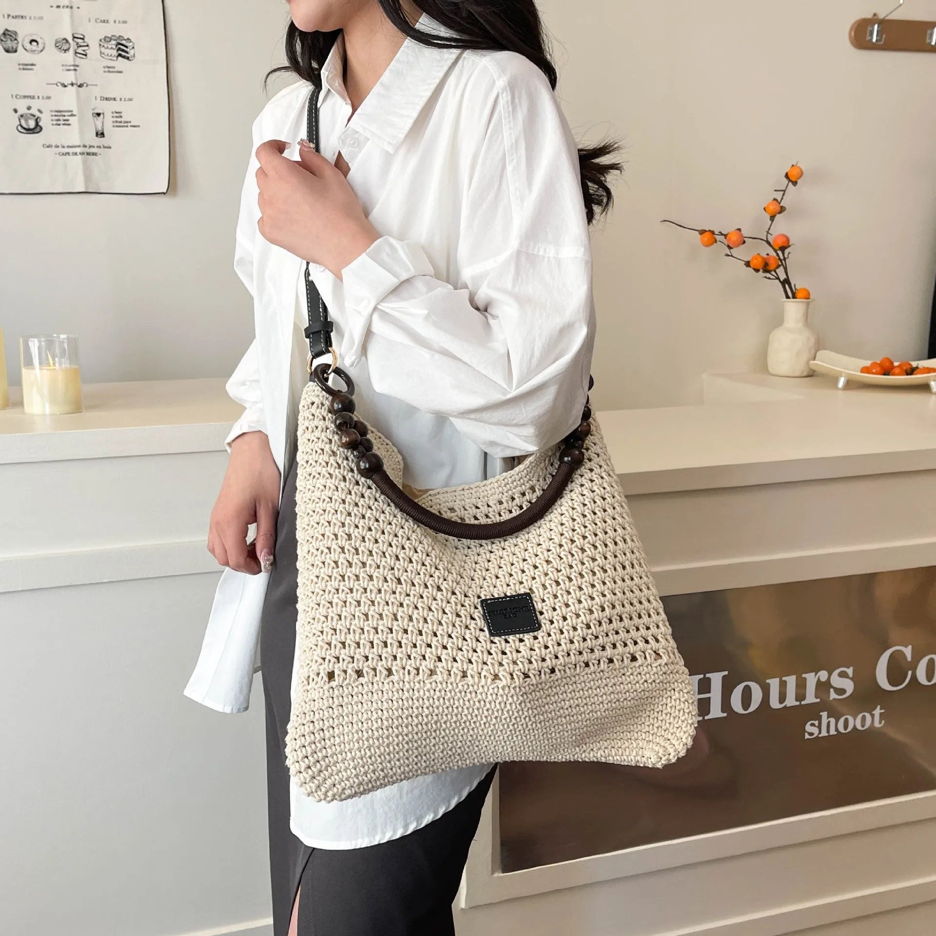 Large capacity knitted tote beach bag in brown with contrast stitching, bucket shape, crossbody strap, and zipped internal compartment