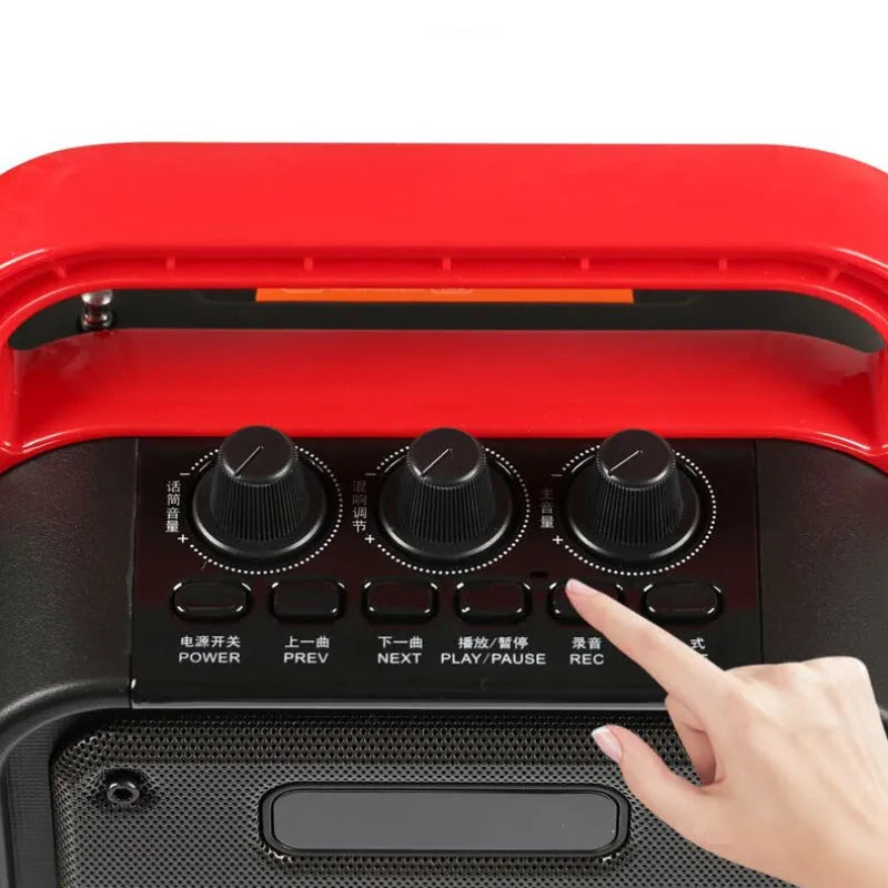 MS62AI portable Bluetooth speaker with wireless microphone on a table, showing remote control and charging cable.