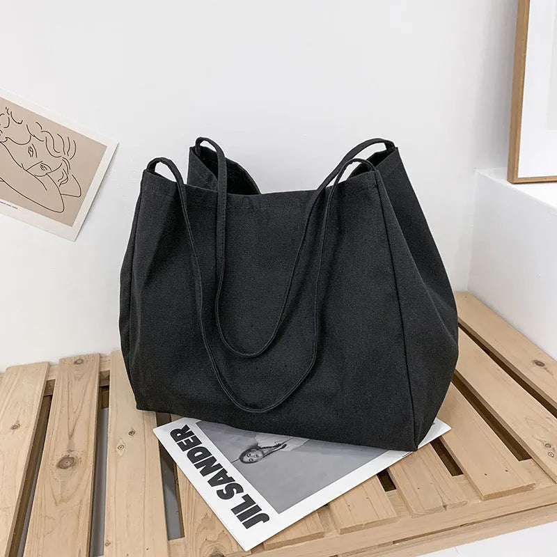 Solid colour women's canvas handbag in black with double shoulder straps and external sandwich pocket