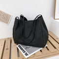 Solid colour women's canvas handbag in black with double shoulder straps and external sandwich pocket