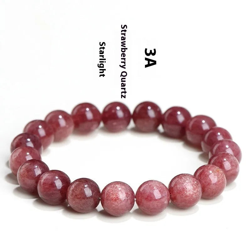 Natural red strawberry quartz crystal bracelet with geometric beads showing a starlight effect, laid flat.
