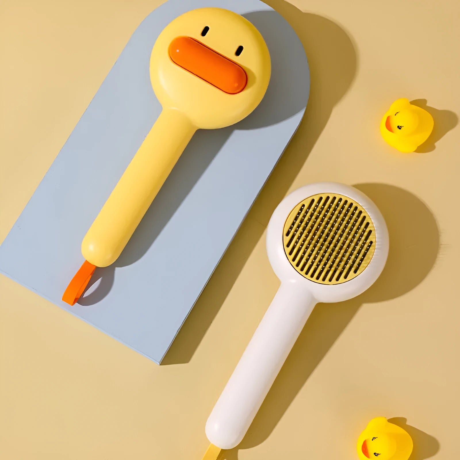 Small yellow duck-shaped pet comb for cat and dog grooming with needle teeth