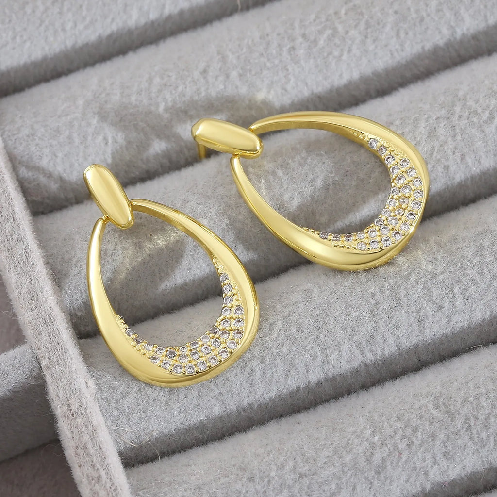 Women's yellow gold geometric drop earrings with simple zircon detail showing oval and round design elements