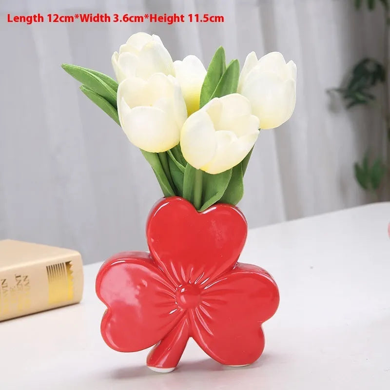 White porcelain clover ceramic vase in European style on a desktop.