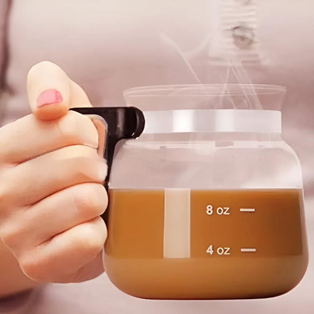 Transparent borosilicate glass coffee maker with black silicone thermal cover on a kitchen counter.