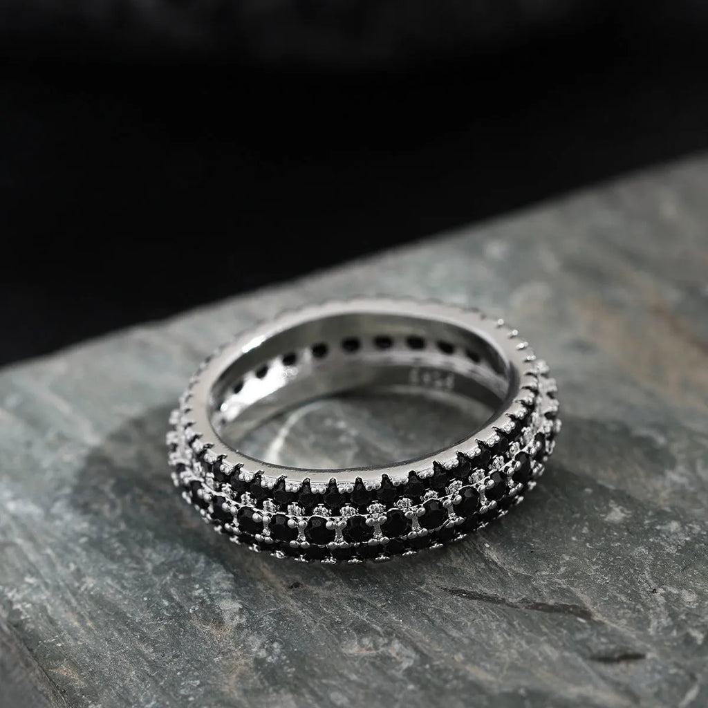 Geometric copper ring with triangular zircon stone and gang drill pattern on band.