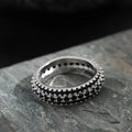 Geometric copper ring with triangular zircon stone and gang drill pattern on band.