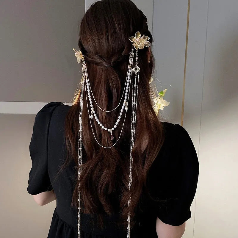 Gold acrylic hairpin with a pearl and diamond flower decoration and a long tassel.