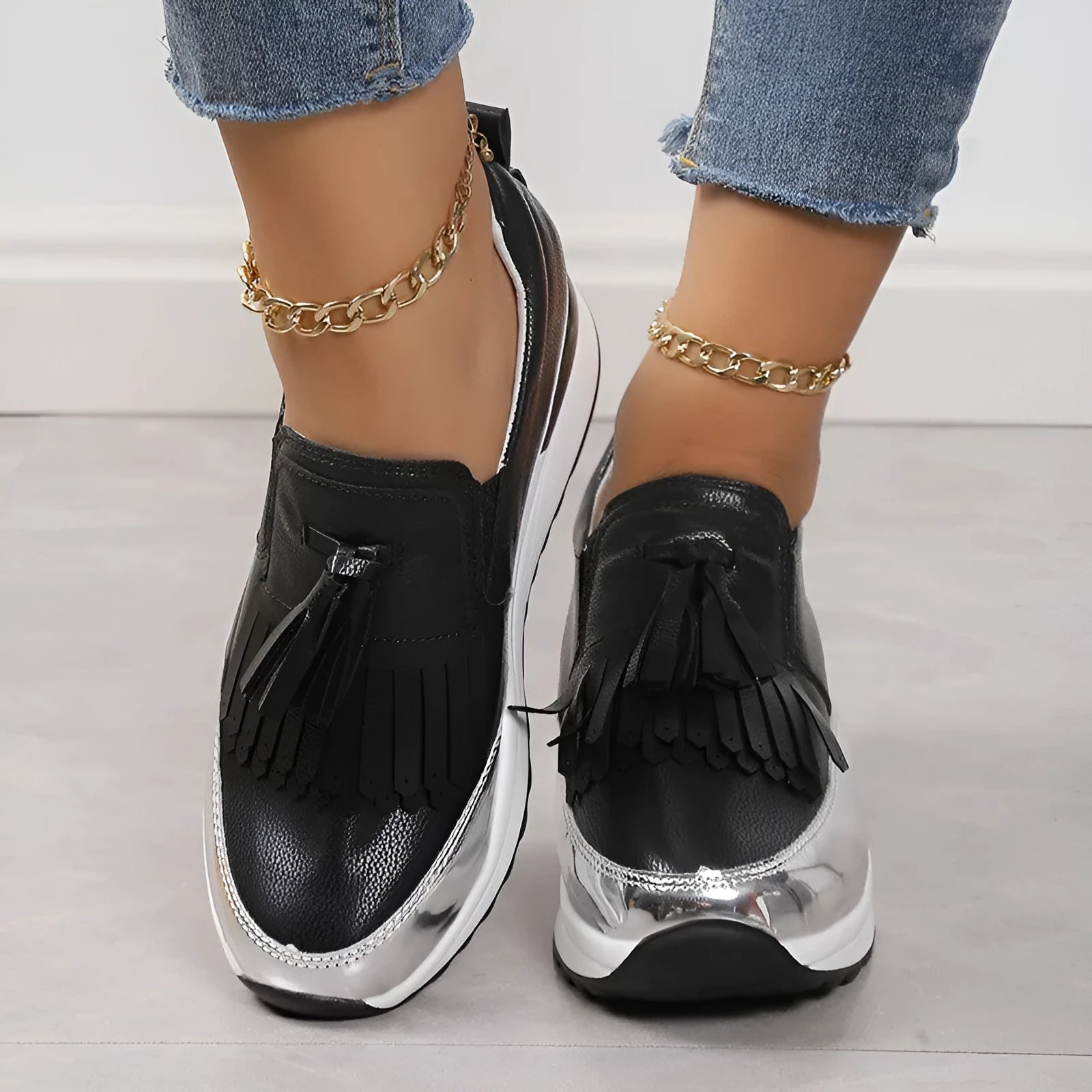 Women's black tassel platform casual shoe with wedge heel, low top, and round toe on a white background