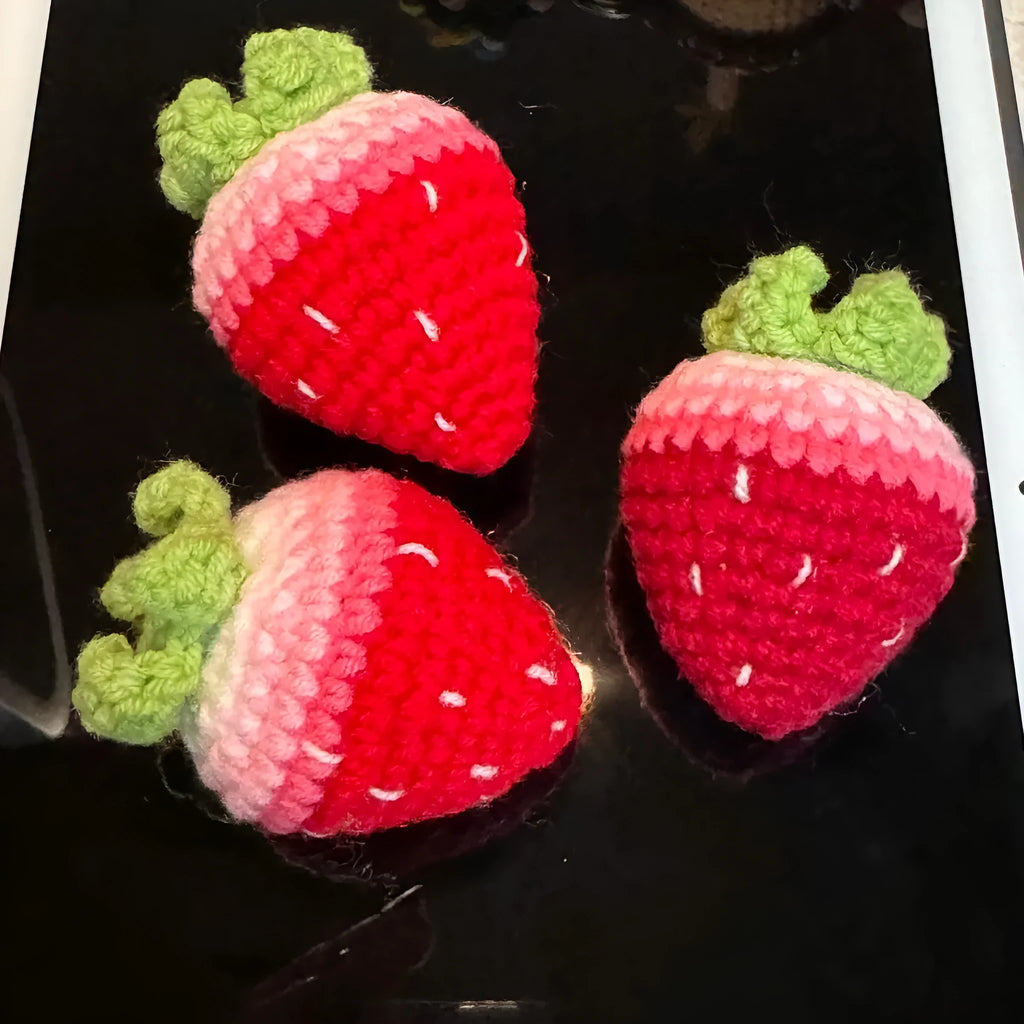 Plush strawberry pendant keychain in pink with metal ring on a white background